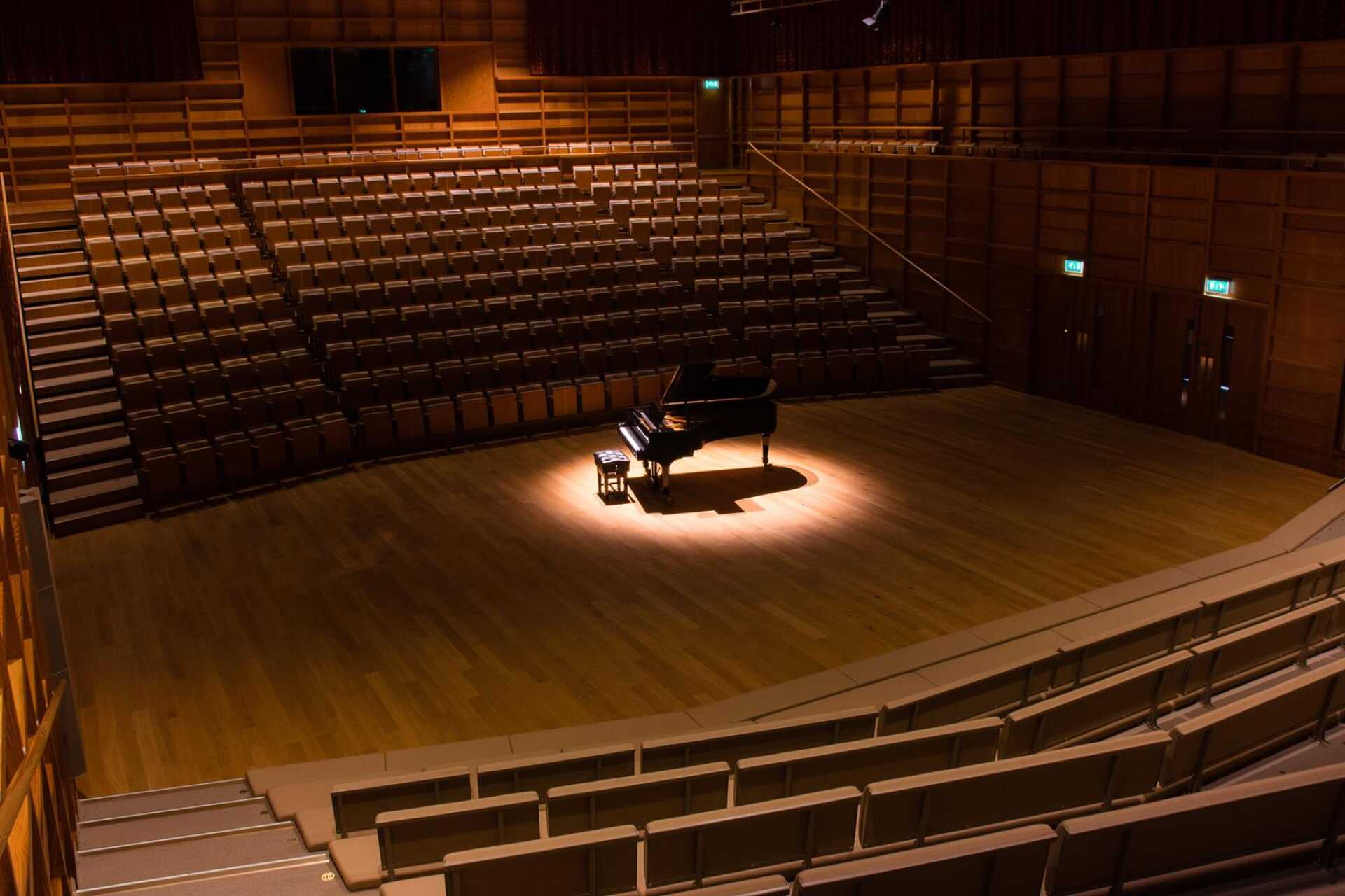 A spotlit piano and stool in the Colyer-Fergusson building