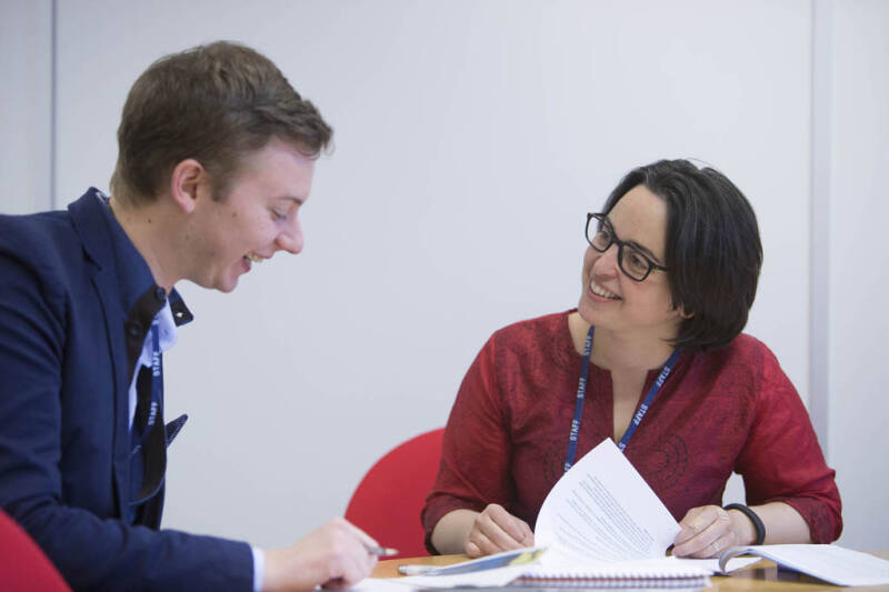 Member of staff helping a student with paperwork