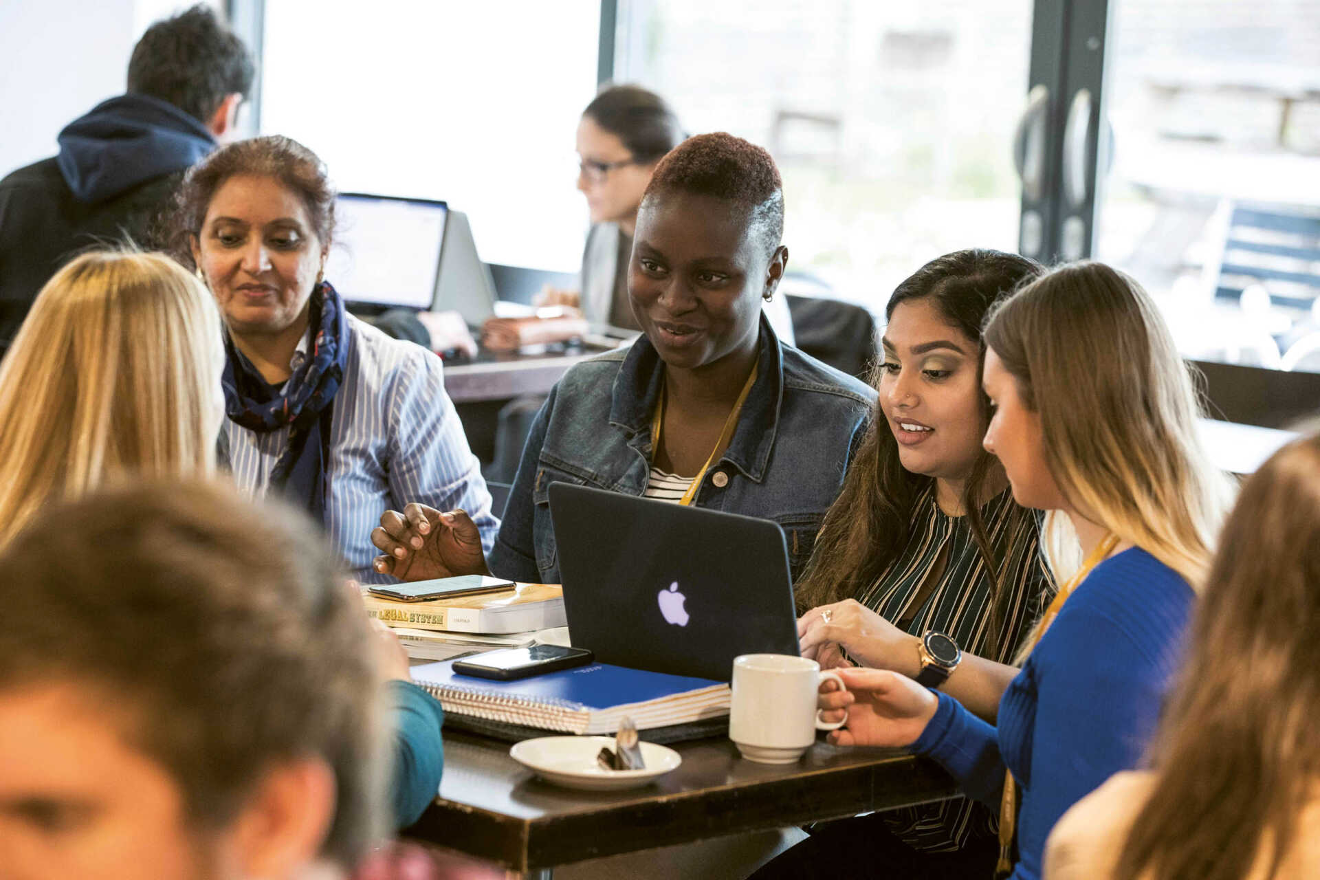 Group of female students working and talking in a cafe on campus