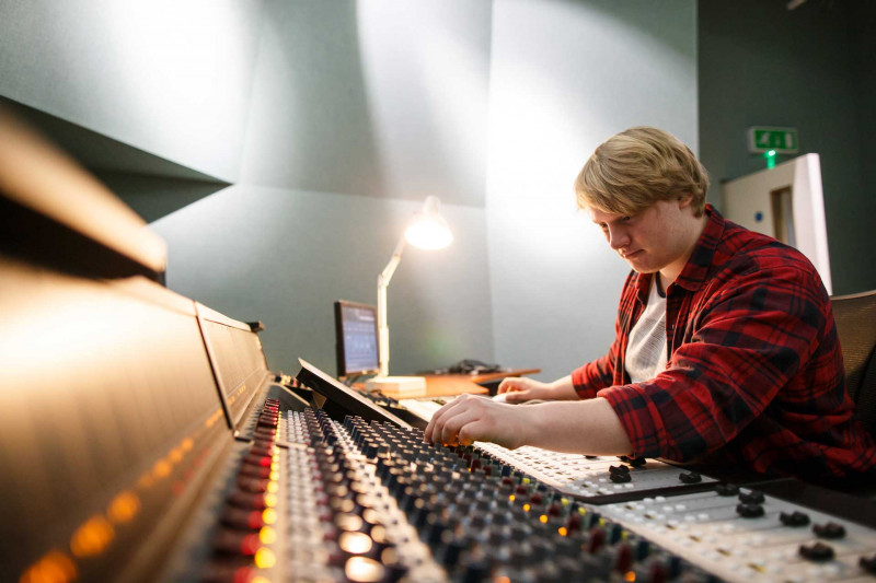 Male student using a mixing desk
