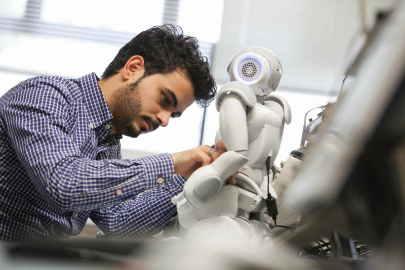 Young male working on a robot.