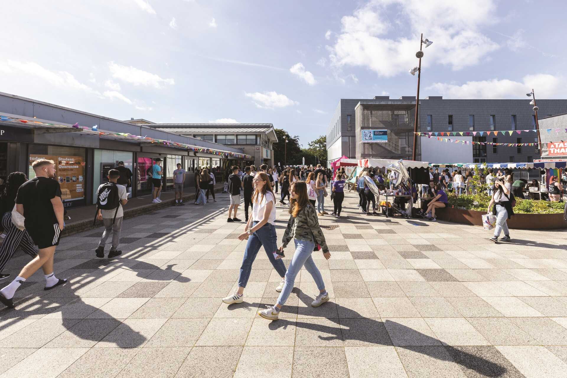 Students in the Plaza on a sunny day with fair in progress