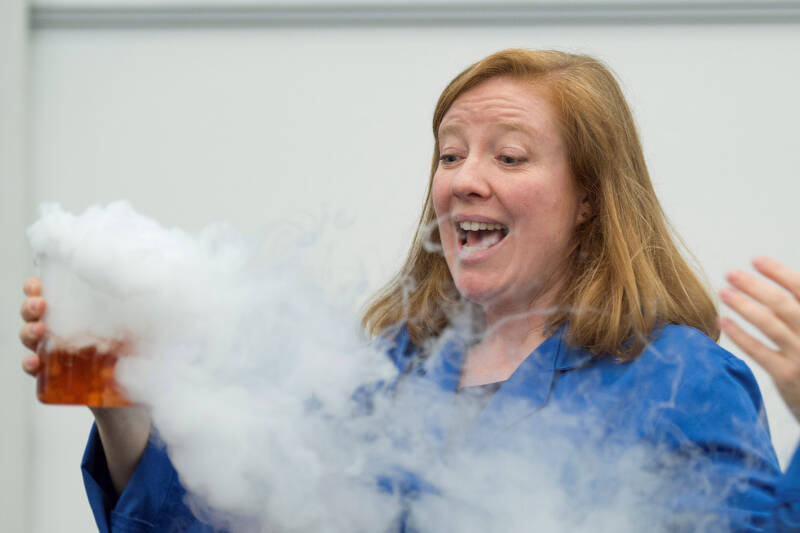 Science teacher creates smoke from a beaker in a chemistry laboratory